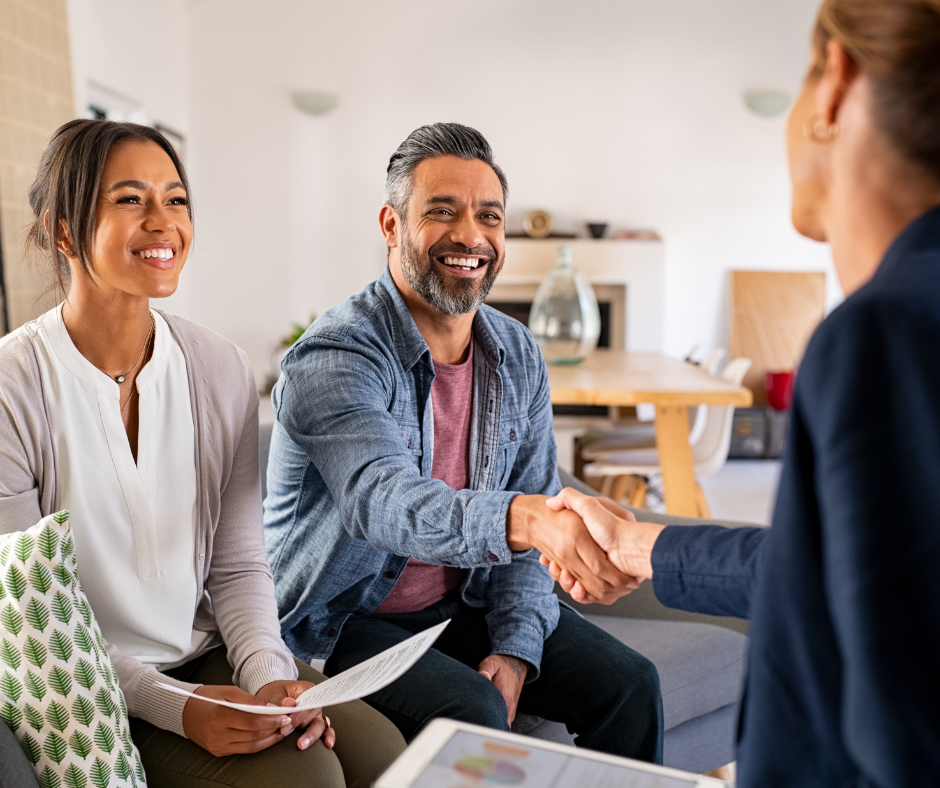 Retired man shaking hands with a financial consultant as his wife reviews a financial statement
