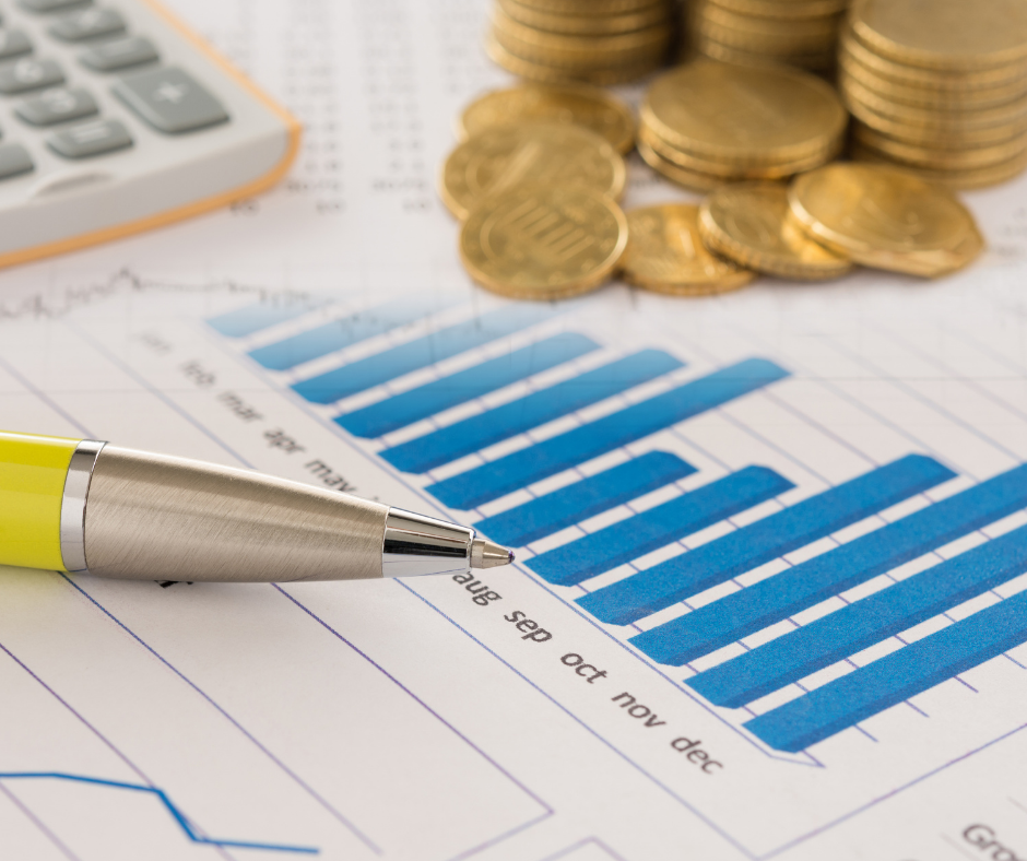 Calculator, coins, pen, and monthly financial graph for retirement income planning